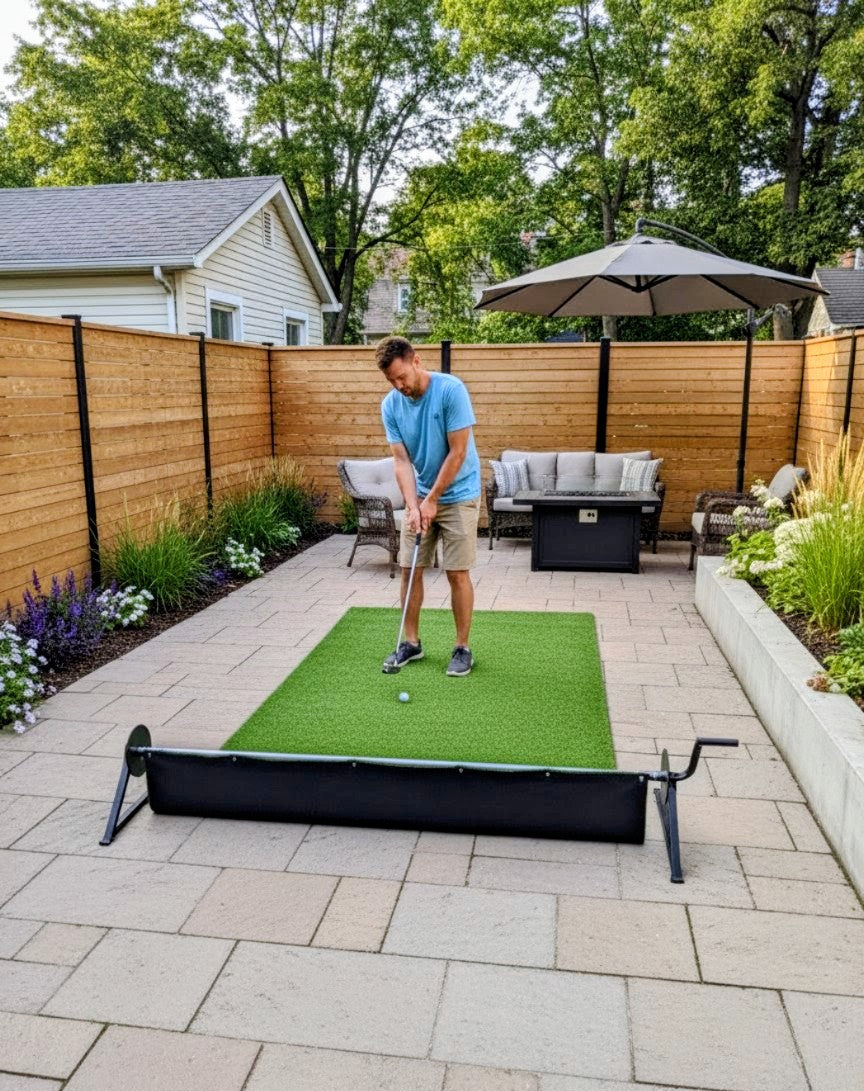Man practicing golf putting on the PlayTurfs retractable artificial turf system, used as a mini putting green on a paved backyard patio.