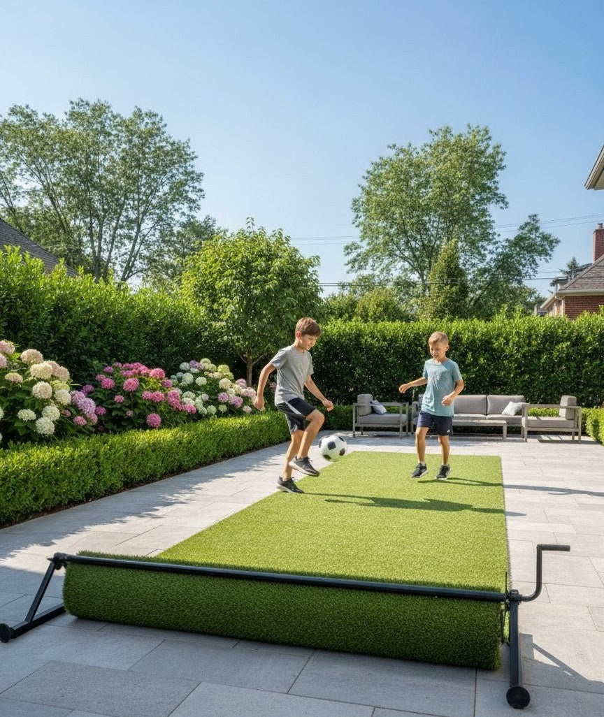 Two children playing soccer on the PlayTurfs retractable artificial turf system set up on a spacious backyard patio.